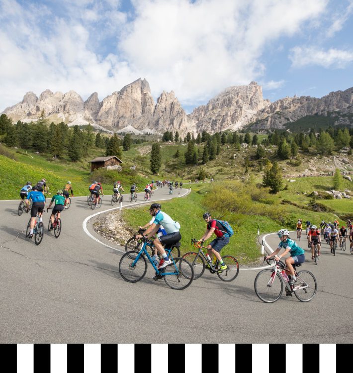 Cyclists on a scenic road during Sellaronda Bike Day 2024, Dolomites, technical cycling apparel, mountain landscape